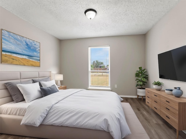638 Matador Dr, Little Elm, TX 75068 - bedroom featuring wood finished floors, a textured ceiling, and baseboards
