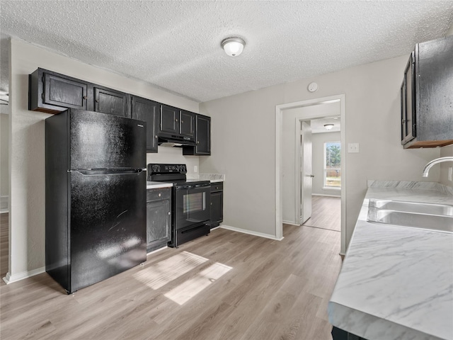 638 Matador Dr, Little Elm, TX 75068 - kitchen featuring black appliances, under cabinet range hood, a sink, light countertops, and light wood-type flooring