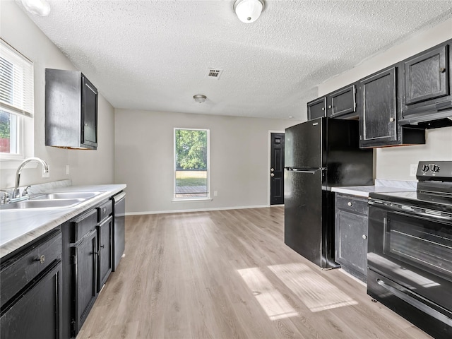 638 Matador Dr, Little Elm, TX 75068 - kitchen featuring black appliances, a sink, under cabinet range hood, light wood finished floors, and light countertops