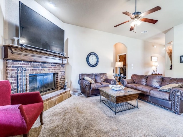 2103 Ridgewood Dr, Bridgeport, TX 76426 - living area featuring carpet flooring, a brick fireplace, ceiling fan, and arched walkways
