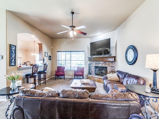 2103 Ridgewood Dr, Bridgeport, TX 76426 - living area with ceiling fan, a fireplace, arched walkways, carpet, and baseboards