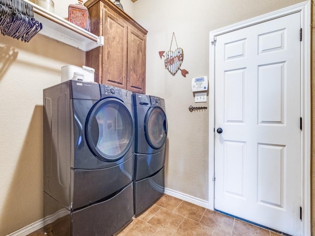 2103 Ridgewood Dr, Bridgeport, TX 76426 - laundry room featuring washing machine and clothes dryer, cabinet space, light tile patterned floors, and baseboards