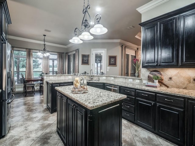 1650 Winding Creek Ln, Rockwall, TX 75032 - kitchen featuring dark cabinets, a center island, a peninsula, a chandelier, and ornamental molding