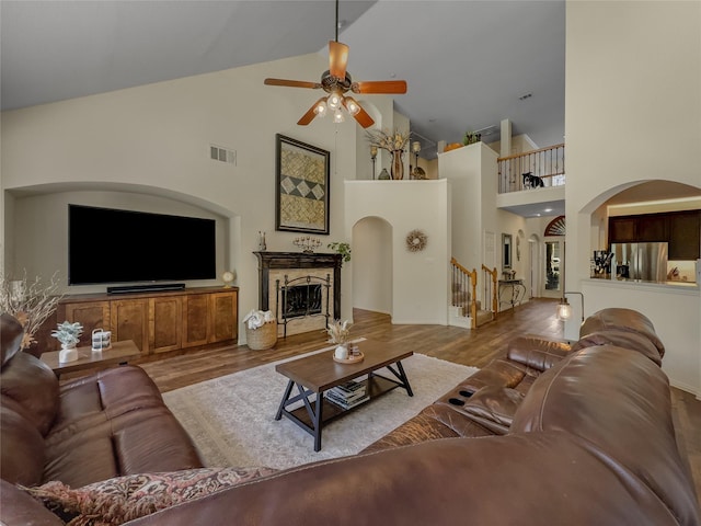 4305 Diplomacy Dr, Rowlett, TX 75089 - living room with ceiling fan, high vaulted ceiling, stairs, wood finished floors, and arched walkways