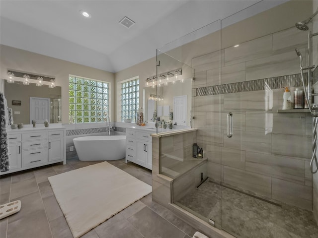 4305 Diplomacy Dr, Rowlett, TX 75089 - full bathroom with a stall shower, a soaking tub, lofted ceiling, tile patterned floors, and two vanities