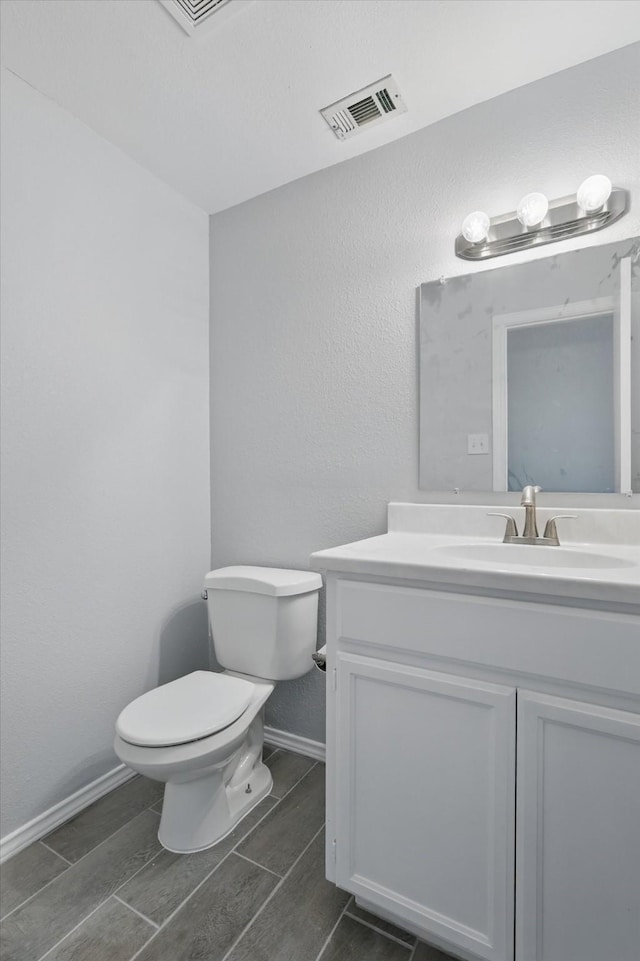 7710 Sable Ln, North Richland Hills, TX 76182 - half bathroom featuring toilet, vanity, baseboards, and wood tiled floors