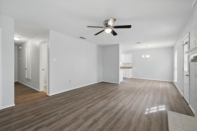 7710 Sable Ln, North Richland Hills, TX 76182 - unfurnished living room with ceiling fan, dark wood-type flooring, a chandelier, and baseboards