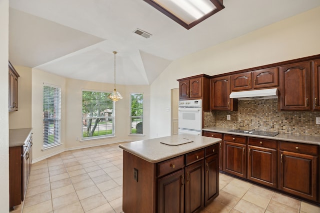 1086 Whispering Gln, Rockwall, TX 75087 - kitchen with under cabinet range hood, black electric stovetop, light tile patterned floors, tasteful backsplash, and lofted ceiling