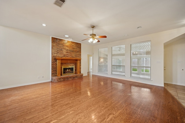 1086 Whispering Gln, Rockwall, TX 75087 - unfurnished living room featuring ceiling fan, a brick fireplace, wood finished floors, recessed lighting, and baseboards