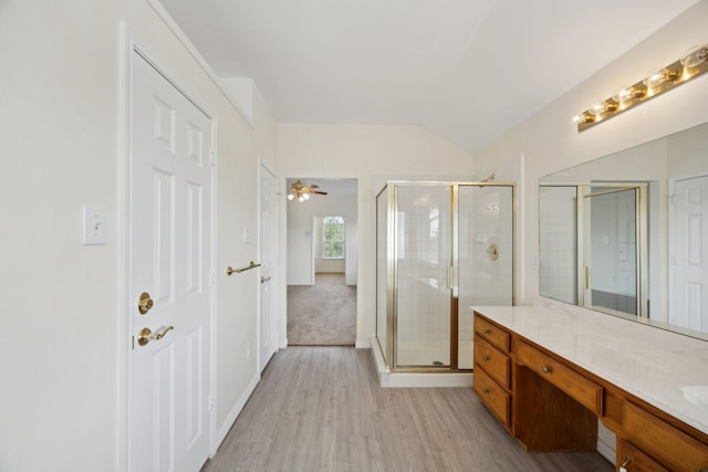 1086 Whispering Gln, Rockwall, TX 75087 - full bath with a stall shower, wood finished floors, vanity, vaulted ceiling, and ceiling fan