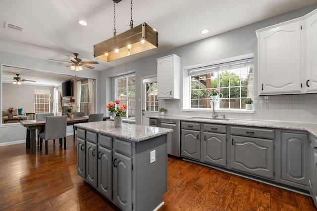 kitchen featuring gray cabinetry, stainless steel dishwasher, a sink, white cabinets, and recessed lighting