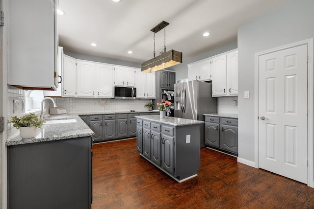 kitchen with gray cabinets, appliances with stainless steel finishes, a sink, backsplash, and recessed lighting