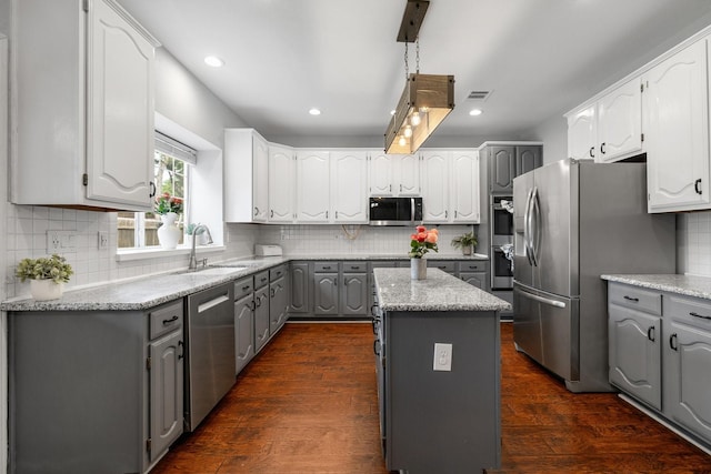 kitchen featuring gray cabinets, stainless steel appliances, decorative backsplash, a sink, and recessed lighting