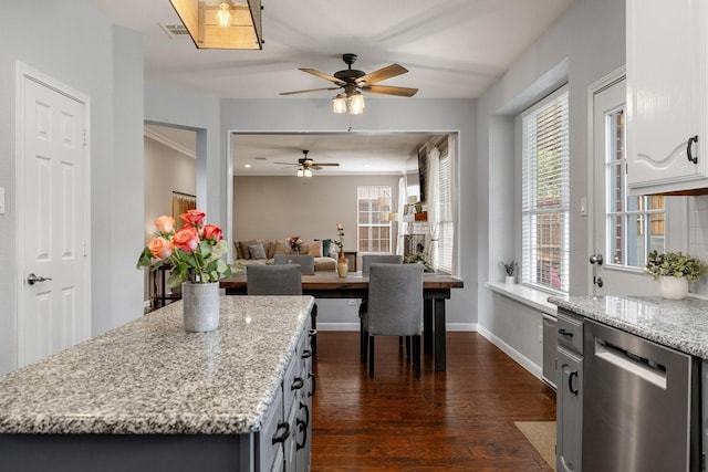 kitchen with stainless steel dishwasher, a ceiling fan, dark wood-type flooring, light stone counters, and baseboards