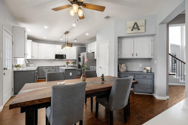 dining room with a ceiling fan, stairs, dark wood finished floors, baseboards, and recessed lighting