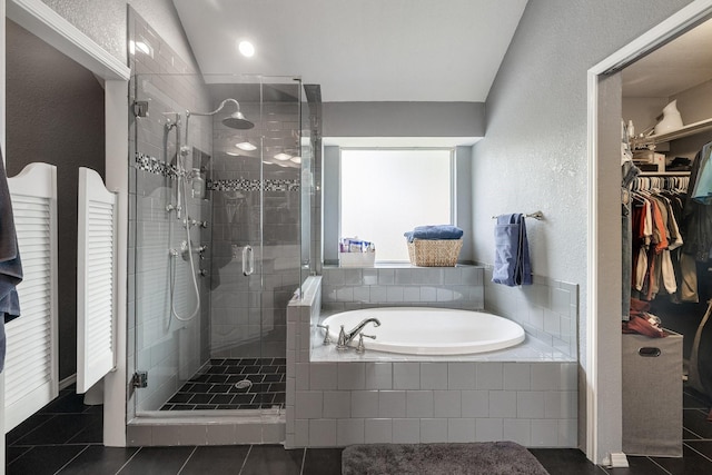 full bathroom with a bath, a stall shower, tile patterned flooring, a spacious closet, and a textured wall