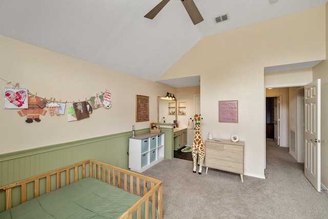 bedroom with vaulted ceiling, carpet flooring, a wainscoted wall, and ceiling fan