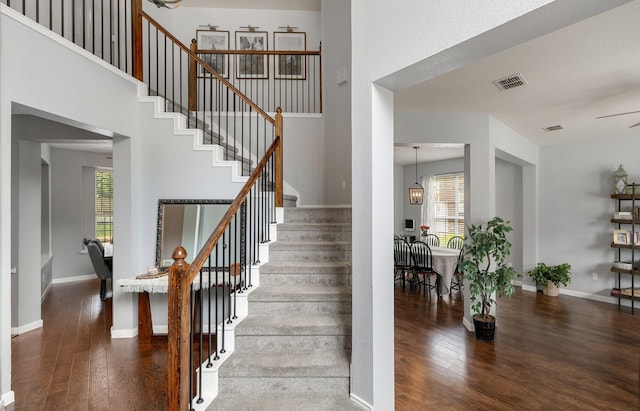 staircase featuring wood finished floors, plenty of natural light, and baseboards