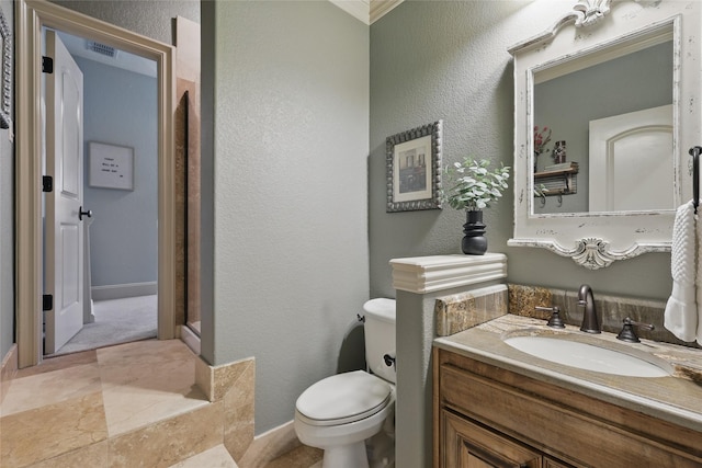 603 Comal Ct, Keller, TX 76248 - bathroom featuring toilet, vanity, baseboards, a textured wall, and crown molding