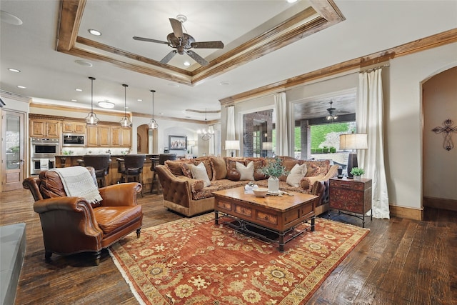 603 Comal Ct, Keller, TX 76248 - living area with arched walkways, ornamental molding, ceiling fan, a tray ceiling, and dark wood finished floors