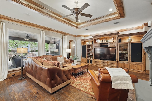 603 Comal Ct, Keller, TX 76248 - living room with a ceiling fan, a tray ceiling, crown molding, dark wood-style flooring, and arched walkways