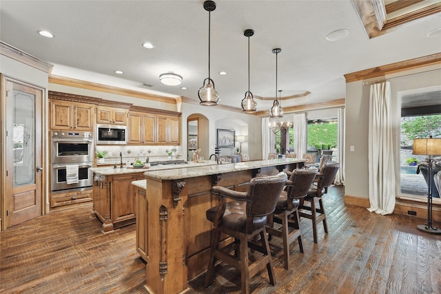 603 Comal Ct, Keller, TX 76248 - kitchen featuring a kitchen island with sink, stainless steel appliances, crown molding, recessed lighting, and dark wood-style floors