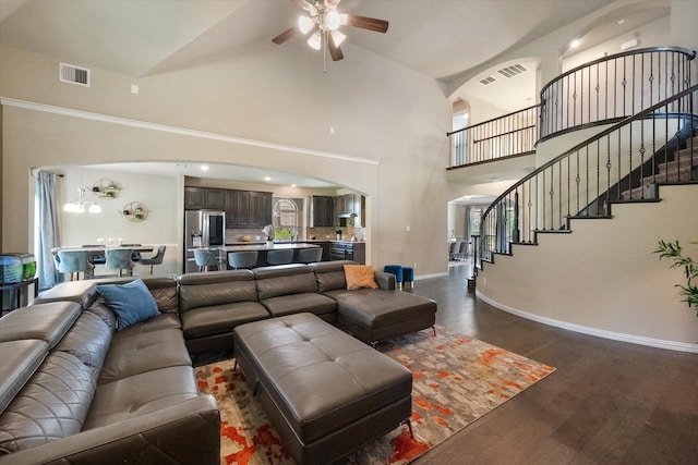 3449 Ava Dr, Midlothian, TX 76065 - living room with arched walkways, ceiling fan, a towering ceiling, baseboards, and stairs
