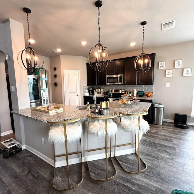 5202 Fallen Tree Dr, Temple, TX 76502 - kitchen with stainless steel appliances, a chandelier, dark wood-type flooring, a sink, and tasteful backsplash