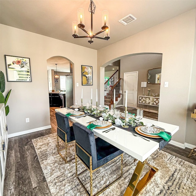 5202 Fallen Tree Dr, Temple, TX 76502 - dining area featuring arched walkways, a chandelier, dark wood-style floors, and baseboards
