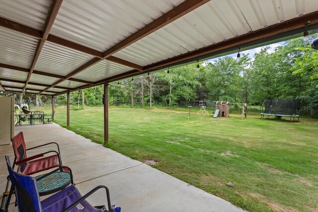 7909 W Fm 1753, Ravenna, TX 75476 - view of patio / terrace featuring a trampoline, a playground, and view of scattered trees