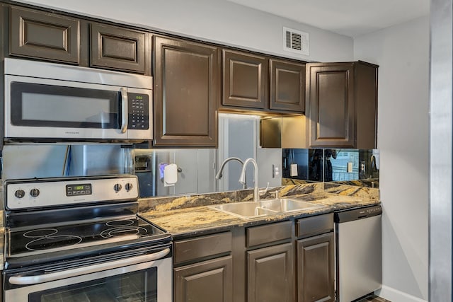 10240 Regal Oaks Dr Unit C, Dallas, TX 75230 - kitchen featuring stainless steel appliances, a sink, dark brown cabinets, and stone counters