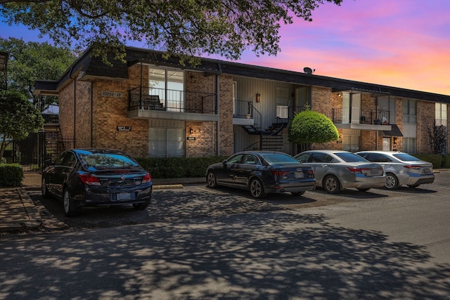 10240 Regal Oaks Dr Unit C, Dallas, TX 75230 - view of property featuring brick siding, uncovered parking, and stairs
