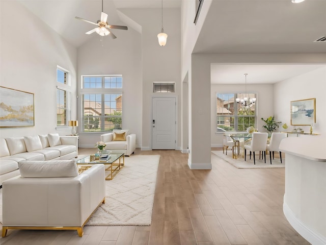 6020 Paddock Ln, Little Elm, TX 76227 - living area featuring light wood-style floors, a ceiling fan, baseboards, a chandelier, and a high ceiling
