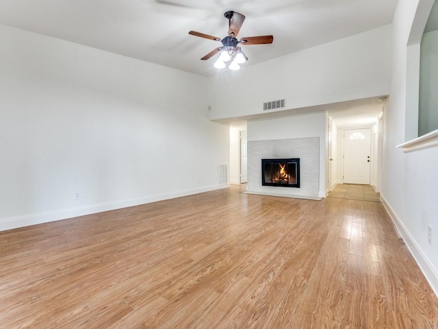 1804 Shreveport Trl, Plano, TX 75023 - unfurnished living room featuring a glass covered fireplace, a ceiling fan, light wood-style flooring, baseboards, and arched walkways