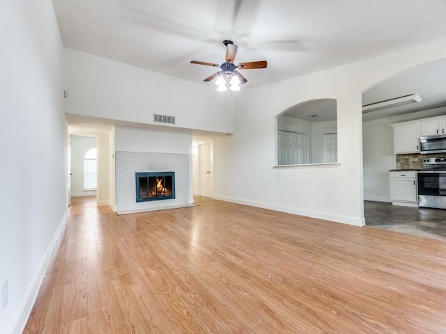 1804 Shreveport Trl, Plano, TX 75023 - unfurnished living room with ceiling fan, light wood-type flooring, baseboards, and a glass covered fireplace