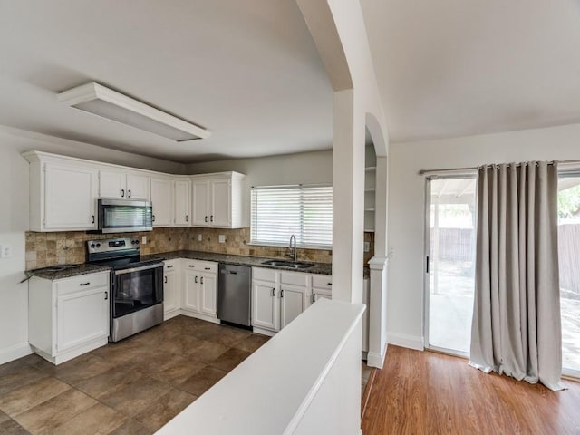 1804 Shreveport Trl, Plano, TX 75023 - kitchen with stainless steel appliances, tasteful backsplash, white cabinetry, dark countertops, and a sink