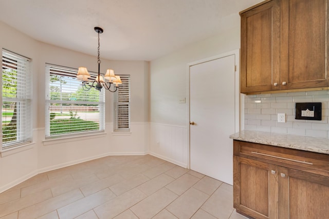 926 Meadowbrook Dr, Grapevine, TX 76051 - unfurnished dining area featuring a chandelier, a wainscoted wall, and light tile patterned flooring