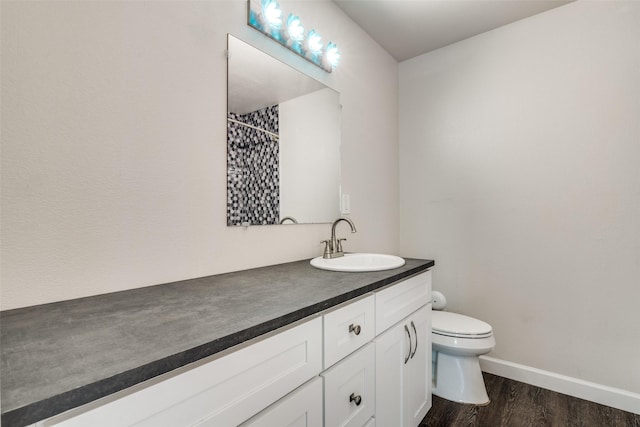 bathroom with wood finished floors, vanity, toilet, curtained shower, and baseboards