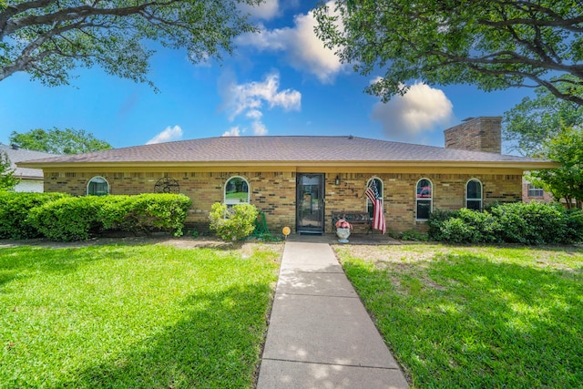 2138 Wellington Dr, Grand Prairie, TX 75051 - ranch-style house featuring a front yard, a chimney, and brick siding