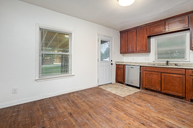 5844 Boone St, Sachse, TX 75048 - kitchen featuring dishwasher, light wood-style flooring, brown cabinets, and a textured ceiling