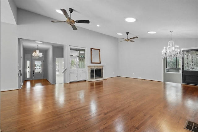 202 Rainbow Cir, Rockwall, TX 75032 - unfurnished living room featuring a chandelier, ceiling fan, a fireplace with raised hearth, wood finished floors, and recessed lighting