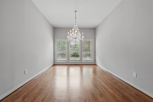 202 Rainbow Cir, Rockwall, TX 75032 - spare room featuring a chandelier, wood finished floors, and baseboards
