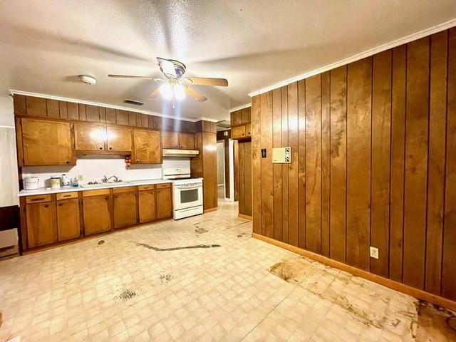 kitchen featuring white range oven, under cabinet range hood, brown cabinetry, a ceiling fan, and light countertops