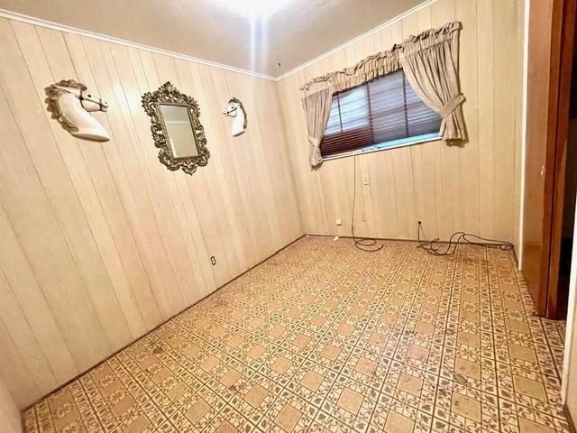 empty room featuring wood walls