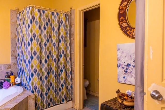 7506 Quail Springs Dr, Arlington, TX 76002 - full bath with a shower with shower curtain, a relaxing tiled tub, and toilet