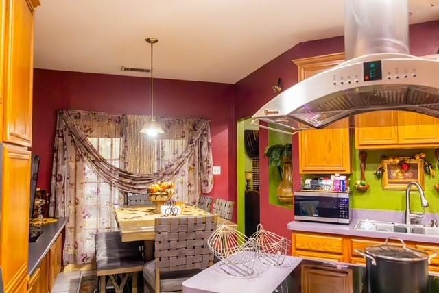 7506 Quail Springs Dr, Arlington, TX 76002 - kitchen with stainless steel microwave, island exhaust hood, a sink, and pendant lighting