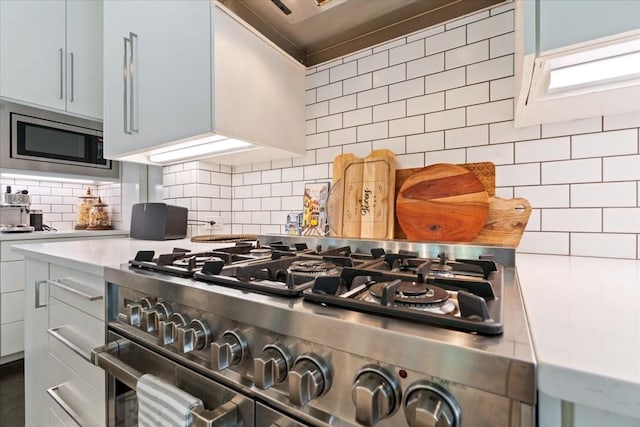 5135 Vickery Blvd, Dallas, TX 75206 - kitchen view of appliances with stainless steel finishes, backsplash, light countertops, and wall chimney range hood
