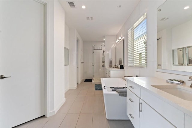 5135 Vickery Blvd, Dallas, TX 75206 - full bathroom with a shower stall, a soaking tub, tile patterned flooring, two vanities, and recessed lighting