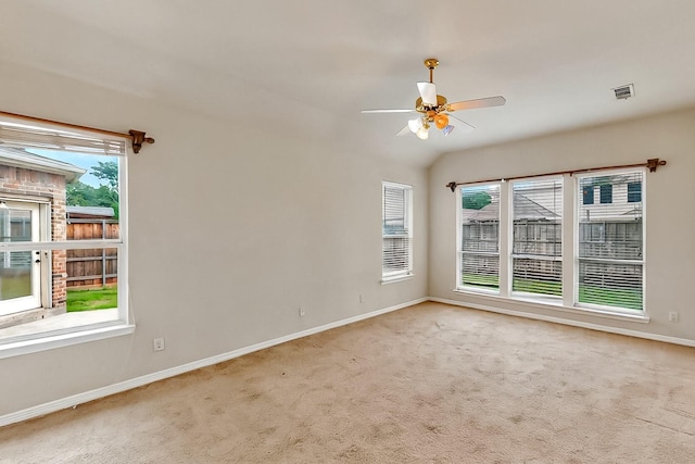 carpeted spare room featuring baseboards, plenty of natural light, and ceiling fan