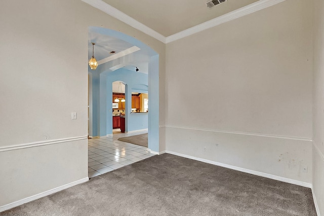 carpeted empty room with arched walkways, ornamental molding, tile patterned floors, and baseboards